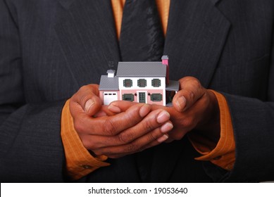 African-American Male Hands Holding A Miniature House.