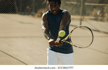 African-American male tennis player on an outdoor court demonstrating powerful arm movements and competitive spirit during a match. - Powered by Shutterstock