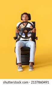 African-American Man In Car Seat And With Steering Wheel On Color Background