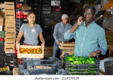 African-american Man Vegetable Warehouse Manager Talking On Phone In Storeroom.