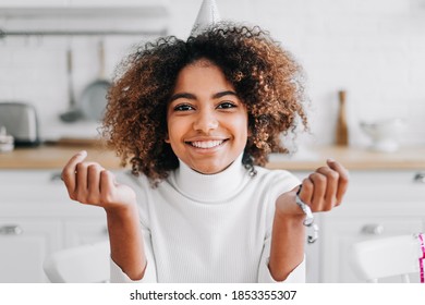 African-American model with trendy kinky hair and dark skin holds in hands decorative confetti smiling widely close view