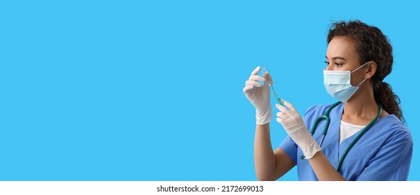 African-American Nurse With Vaccine On Blue Background With Space For Text