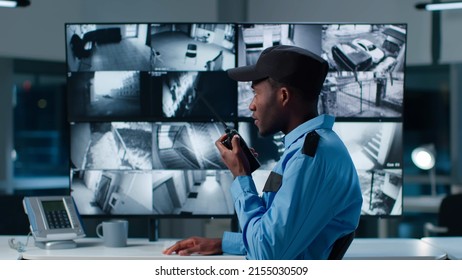 African-American security officer watching the screens talking on radio in control room  - Powered by Shutterstock