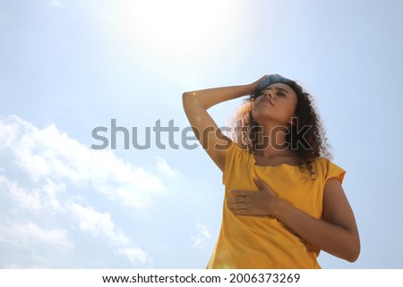 African-American woman with cold pack suffering from heat stroke outdoors