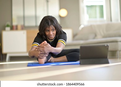 African-american Woman Doing Virtual Fitness Exercices, Digital Class On Tablet