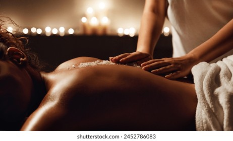 African-american woman enjoying salt scrub massage at spa, closeup - Powered by Shutterstock