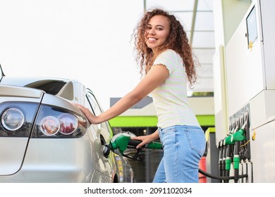 African-American Woman Filling Up Car Tank At Gas Station