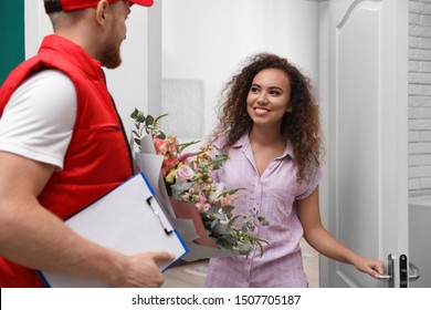 African-American Woman Receiving Flower Bouquet From Delivery Man Indoors