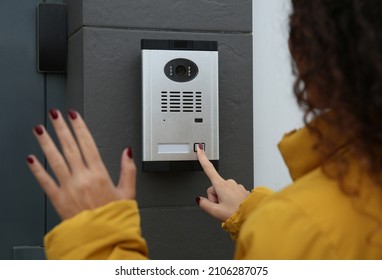 African-American woman ringing intercom while waving to camera near building entrance - Shutterstock ID 2106287075