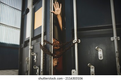 African-American woman, trapped inside an illegal container locked with chains and keys, reaches out for help and seeks freedom from the outside : Human trafficking and illegal immigration. - Shutterstock ID 2116303106