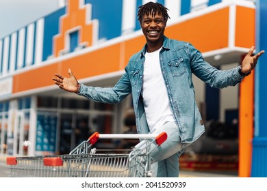 afro american black man with shopping cart in front of mall shopping mall, successful shopping mall, black friday, sale, black friday, joyful emotions