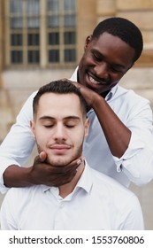 Afro American Boy Holding Caucasian Guy Head By Hands, Wearing White Shirt. Concept Of Stylish Boy And Haircut. Same Sex Couple, Lgbt Gays