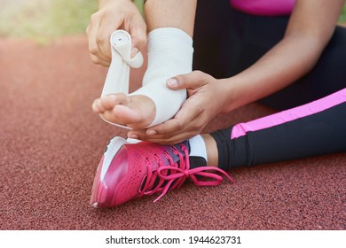 Afro American Girl Putting Bandage On Injured Foot