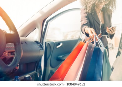 Afro American Girl With Shopping Bags In Car Using Cell Phone