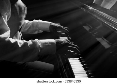 Afro American man hands playing piano in darkness