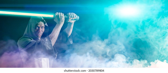 Afro American man holds a laser lightsaber in a Halloween costume