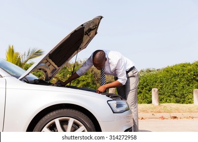 Afro American Man Looking At Broken Down Car Engine By Side Of The Road