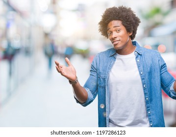 Afro american man over isolated background clueless and confused expression with arms and hands raised. Doubt concept. - Shutterstock ID 1197286123