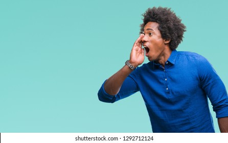 Afro american man over isolated background shouting and screaming loud to side with hand on mouth. Communication concept.