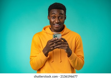 Afro american man using smartphone over isolated mint background