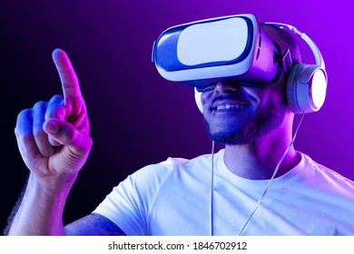 Afro American Man Wearing VR Glasses In Neon Light Against Purple Background