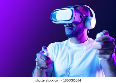Afro American Man Wearing VR Glasses In Neon Light Against Purple Background