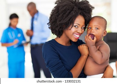 Afro American Mother Holding Her Sick Baby In Doctor's Office