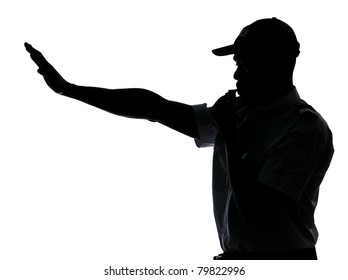 An Afro American Traffic Cop Making Stop Gesture While Blowing Whistle In Studio On White Isolated Background