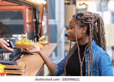 Afro american woman getting a fast food tray from a fast food truck - Powered by Shutterstock