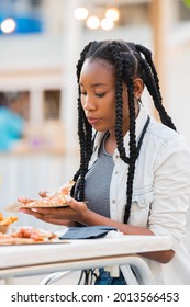 Afro American Woman Picking Up A Pizza Slice At An Outdoors Terrace