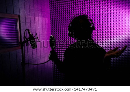 afro american woman with pigtails hairstyle headphones in a cap and a hood sunglasses recording hip hop song track.