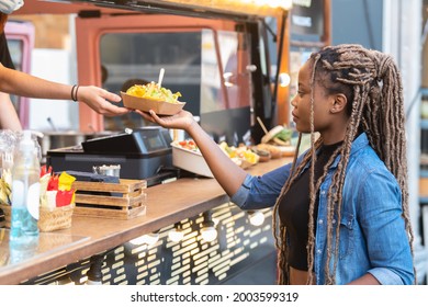 Afro american woman receiving a fast food tray with guacamole and nachos: Selective focus - Powered by Shutterstock