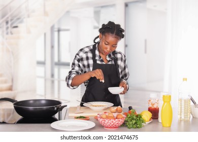 Afro american woman sprinkling salt on whisked eggs: Cooking concept