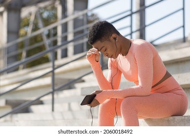 Afro American Woman Tired After Workout Listening To Music And Audio Podcast, After Jogging And Training At Stadium In Morning