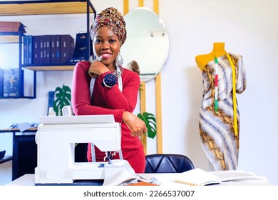 afro american woman with turban over head and silver ethnic colorful jewelry in tailor workshop - Powered by Shutterstock