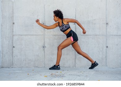 Afro athletic woman running outdoors.