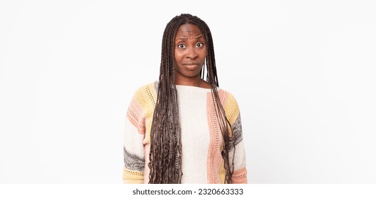 afro black adult woman looking puzzled and confused, biting lip with a nervous gesture, not knowing the answer to the problem