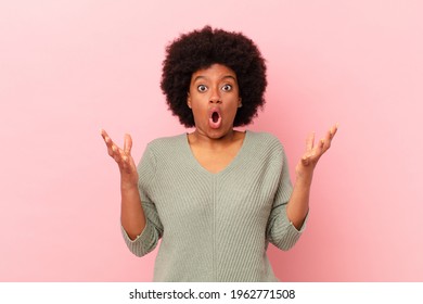 afro black woman open-mouthed and amazed, shocked and astonished with an unbelievable surprise