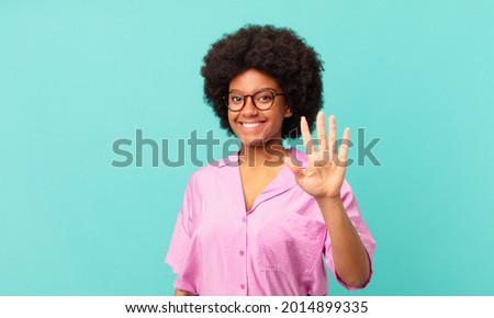 afro black woman smiling and looking friendly, showing number five or fifth with hand forward, counting down