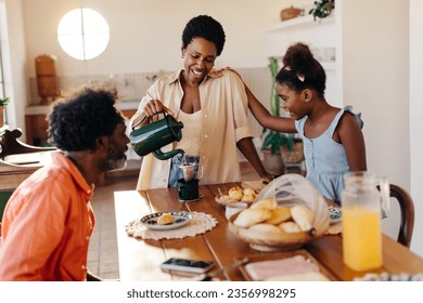 Afro Brazilian family bonding over breakfast at home. They happily enjoy cheese bread and coffee, sharing quality time together. Parents serve food with love, creating a warm and happy atmosphere. - Powered by Shutterstock