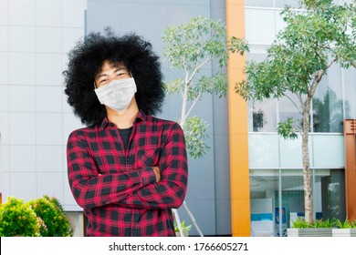 Afro College Student Looks Confident With Folded Arms While Wearing A Mask And Standing At University Yard