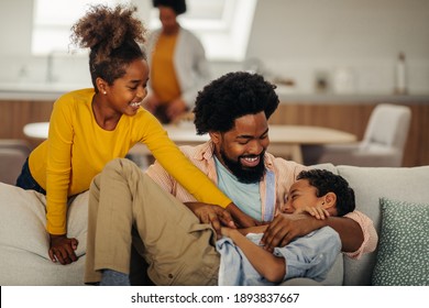 Afro father and children having fun at home