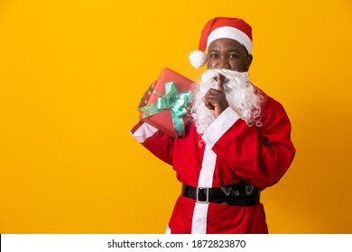 Afro father dressed as Santa Claus holding children's gifts - Powered by Shutterstock