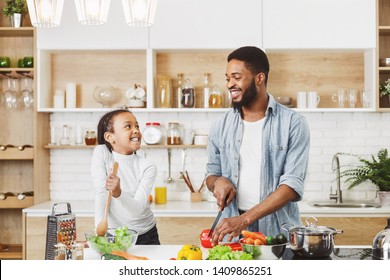 Afro Father And His Little Daughter, Cooking Dinner Together. Cooking Dinner For Mother Concept