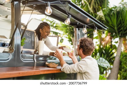 Afro food truck owner serving meal to male customer - Modern business and take away concept  - Powered by Shutterstock