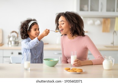 Afro Girl Feeding Young Woman With Cereal