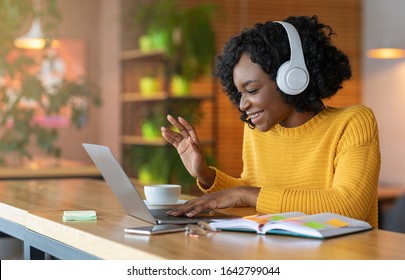 Afro girl in headset using laptop at cafe, having skype conference, free space - Shutterstock ID 1642799044