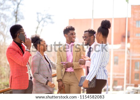 afro guests are waiting for a bride and a groom in the street with modern buildings.