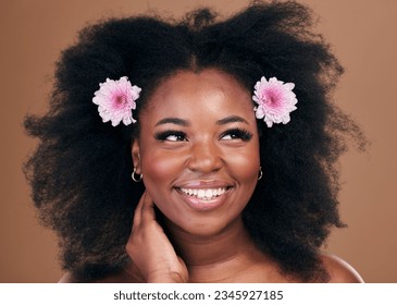 Afro hair, thinking or happy black woman with flowers, beauty or smile on a brown studio background. Hairstyle, floral or natural African female model with shine or growth ideas with wellness or glow
