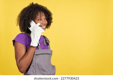 Afro haired female carpenter talking distracted to the mobile - Powered by Shutterstock